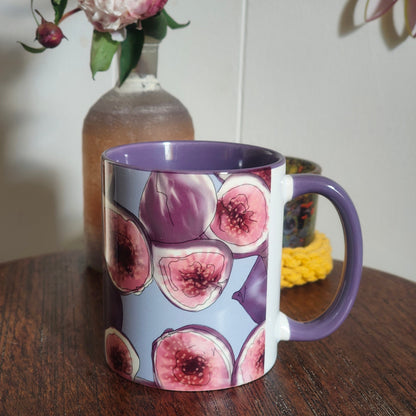 Mug with fig design on a wooden surface with flowers in the background