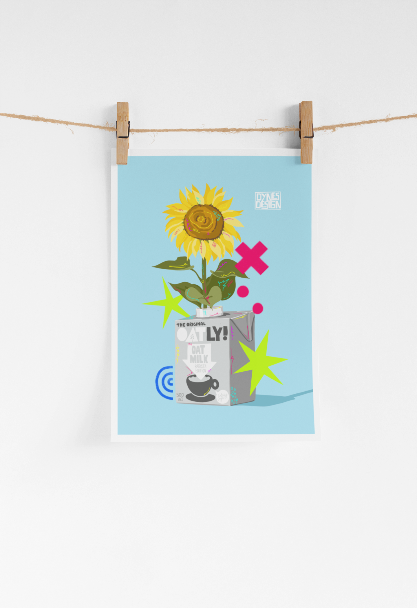 A vertical art print featuring a stylized sunflower in an oat milk carton with colorful star and dot accents on a light blue background, hanging from a string with wooden clothespins against a white wall.