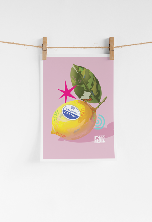 A vertical art print featuring a stylized yellow lemon with a green leaf on a dusty pink background, hanging from a string with two wooden clothespins against a white wall.